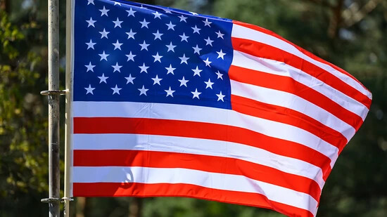 Eine Flagge der USA (Vereinigte Staaten von Amerika) weht bei der Übung «National Guardian 2024» im Teil der Bundeswehrübungsreihe «Quadriga» auf dem Truppenübungsplatz Oberlausitz im Wind. Foto: Robert Michael/dpa