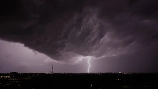 ARCHIV - Blitze zucken in Lenexa, Kansas, während in der Ferne ein Gewitter vorbeizieht. Foto: Charlie Riedel/AP/dpa ARCHIV - Blitze zucken in Lenexa, Kansas, während in der Ferne ein Gewitter vorbeizieht. Foto: Charlie Riedel/AP/dpa